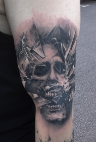 大臂令人毛骨悚然的黑色破碎玻璃与怪物脸纹身图案