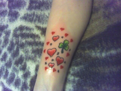 手臂彩色许多红心和三叶草纹身图案