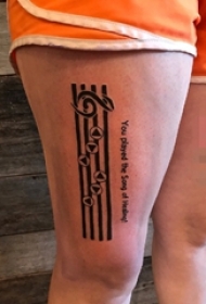 女生大腿上黑色线条五线谱音符纹身图片
