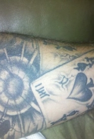 手臂灰色墨水卡枪和扑克牌纹身图案