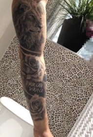 男生手臂上黑白灰色花臂狮子与玫瑰纹身图片
