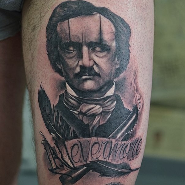 大腿上复古风格恶魔般的男子羽毛和字母纹身图案