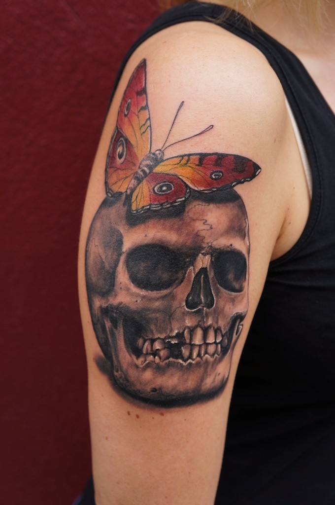 手臂蝴蝶与骷髅头纹身图案