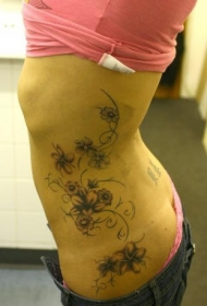 女性腰侧彩色花藤纹身图案
