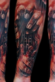 手臂撕裂皮肤风格的彩色血腥手与吉他纹身