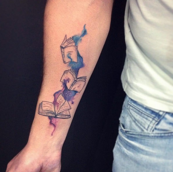 小臂神秘的黑色书与彩色泼墨纹身图案