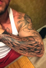 简单的黑色点刺翅膀字母手臂纹身图案