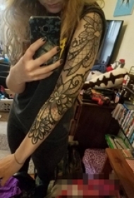 女生手臂上黑色线条花臂花朵纹身图片