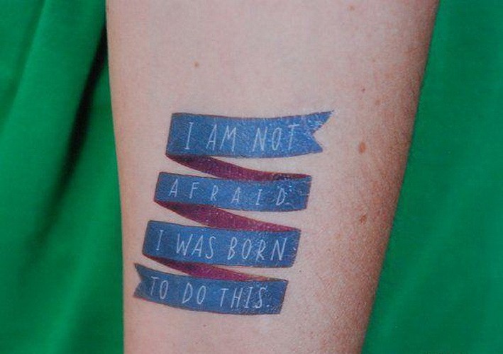 手臂蓝色丝带和白色字母纹身图案