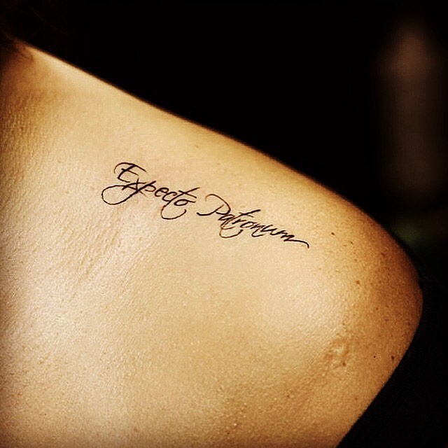 肩部黑色拼写字母纹身图案