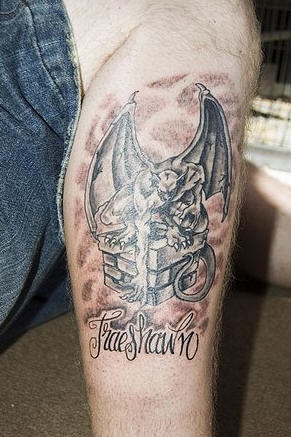 腿部棕色箱子上的石像鬼纹身图案