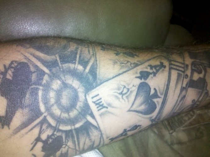 手臂灰色墨水卡枪和扑克牌纹身图案