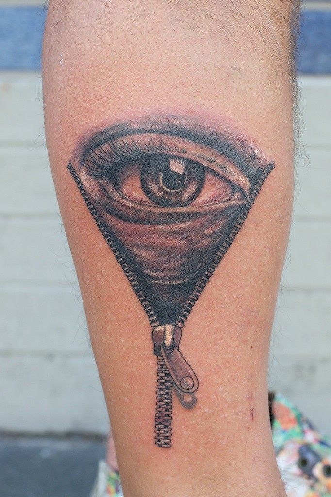 手臂上的逼真眼球和拉链纹身图案