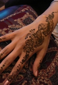 女生手背上黑色抽象线条植物花朵纹身图片