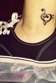 女生小腿上黑色线条心形元素音符纹身图片