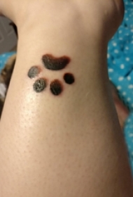 男生手臂上黑灰轮廓可爱狗爪纹身图片