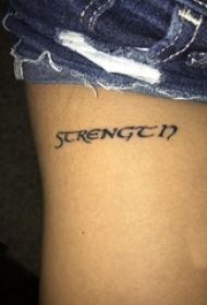 女生大腿上黑色线条文艺花体英文纹身图片