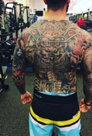 男生后背上彩绘点刺植物花朵和龙纹身图片