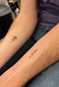 男生手臂上黑色点刺简单线条匕首和花朵纹身图片