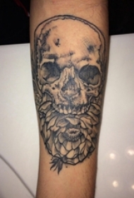 男生手臂上黑色点刺简单线条骷髅和花朵纹身图片