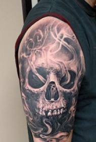 男生大臂上黑色点刺抽象线条骷髅纹身图片
