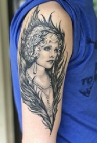 男生手臂上黑色点刺抽象线条羽毛和人物肖像纹身图片