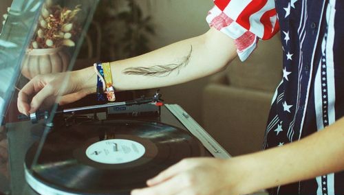 酒吧dj手臂上的羽毛纹身图案欣赏