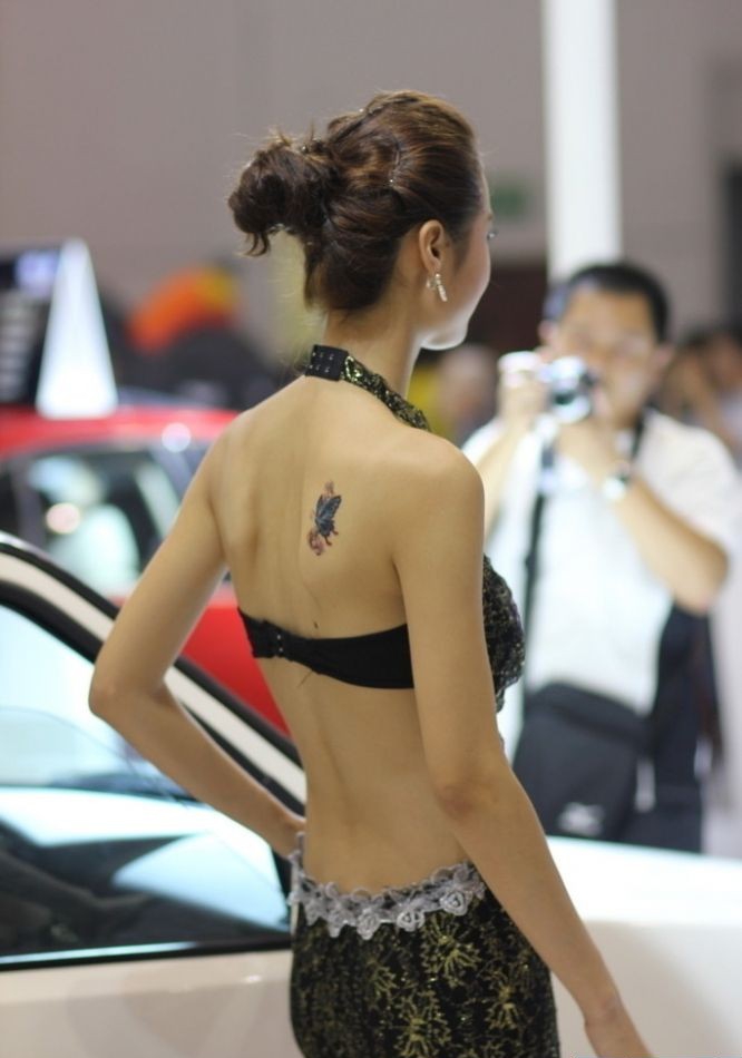 后背上有小清新纹身图案的车模