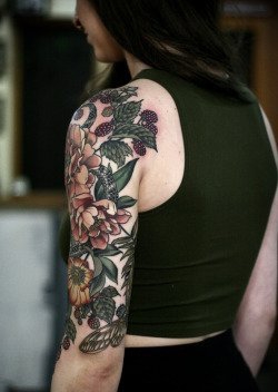 女性左手大臂膀漂亮的花朵纹身图案