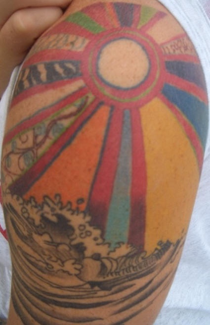 肩部多彩的太阳和波浪纹身图案