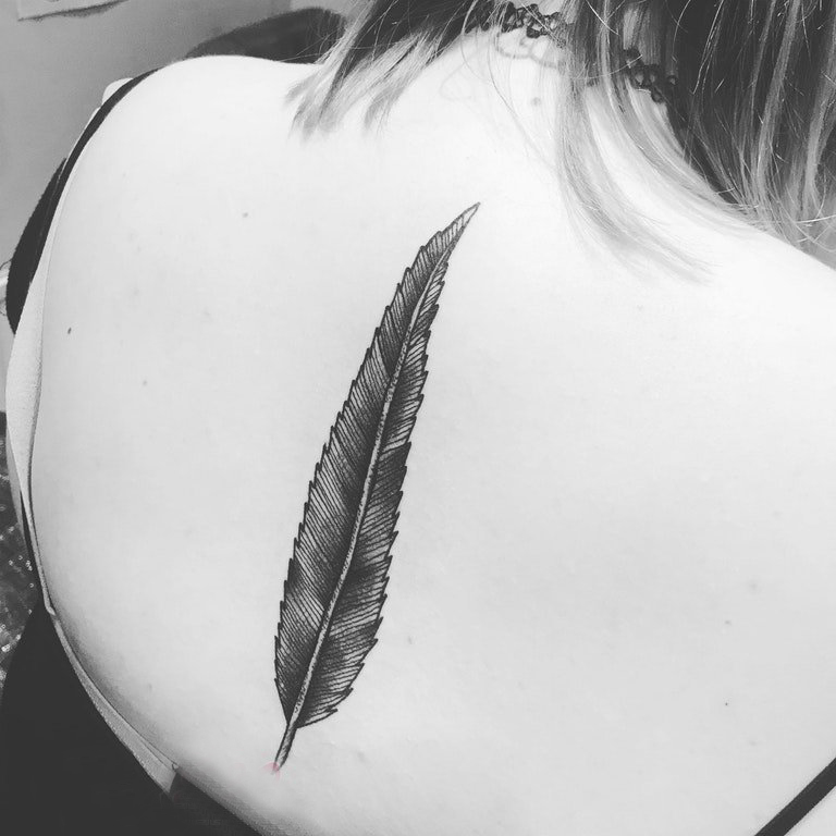 女生后背纹身图 女生后背上黑色的羽毛纹身图片