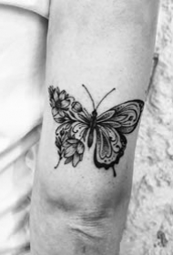 大臂后侧部的手肘拐处的一组小黑图纹身图案