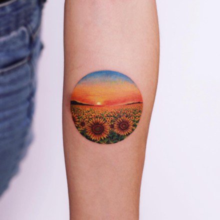手臂上创意的圆形彩色小纹身图片