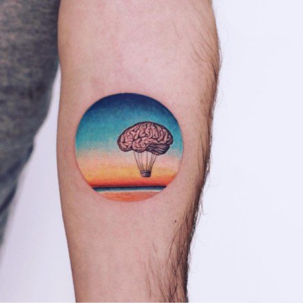 手臂上创意的圆形彩色小纹身图片