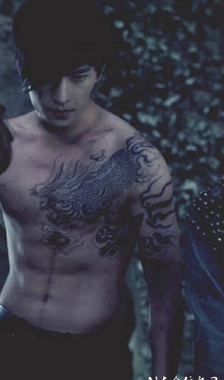 霸气男子半裸展示肩部龙纹身图案