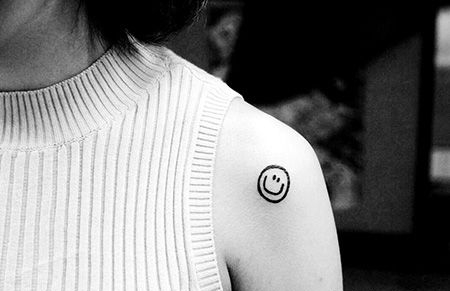 女生肩部笑脸纹身图案