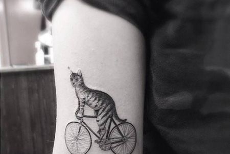 大臂骑着自行车的猫纹身图案