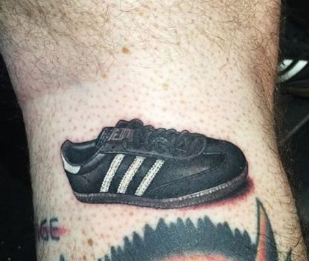 大臂黑色运动鞋纹身图案