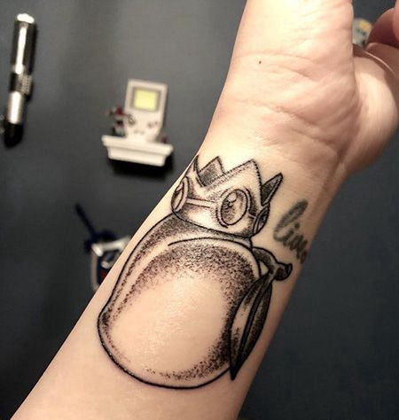 手腕戴着皇冠的桃子纹身图案