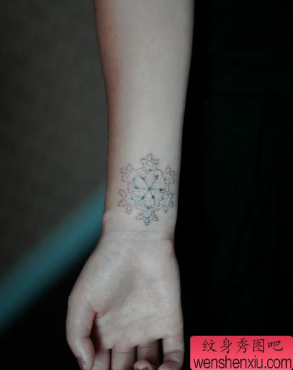女孩子手腕处一款白色雪花纹身图案
