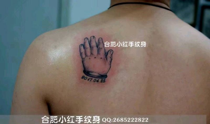 儿子在父亲的背上留下了他的手印纹身图片