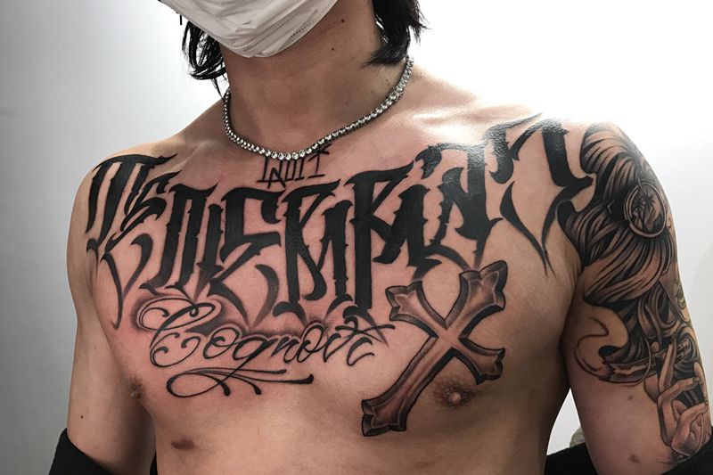 花体英文纹身图片_胸部肩部花体字图腾奇卡诺风格花体英文十字架纹身图案