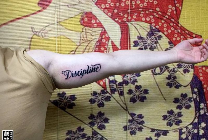 Discipline纹身图片_手臂花体字纹身图案