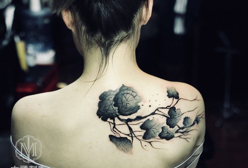 水墨叶子遮盖香奈尔大标纹身图片_背部水墨纹身图案