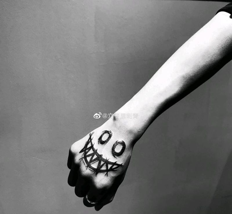 恶魔笑脸纹身图片_手部纹身图案
