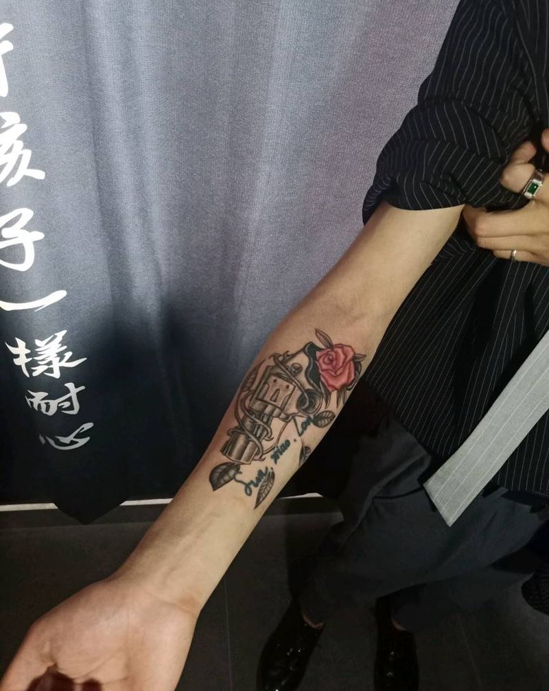 枪与玫瑰与羽毛纹身图片_手臂纹身图案