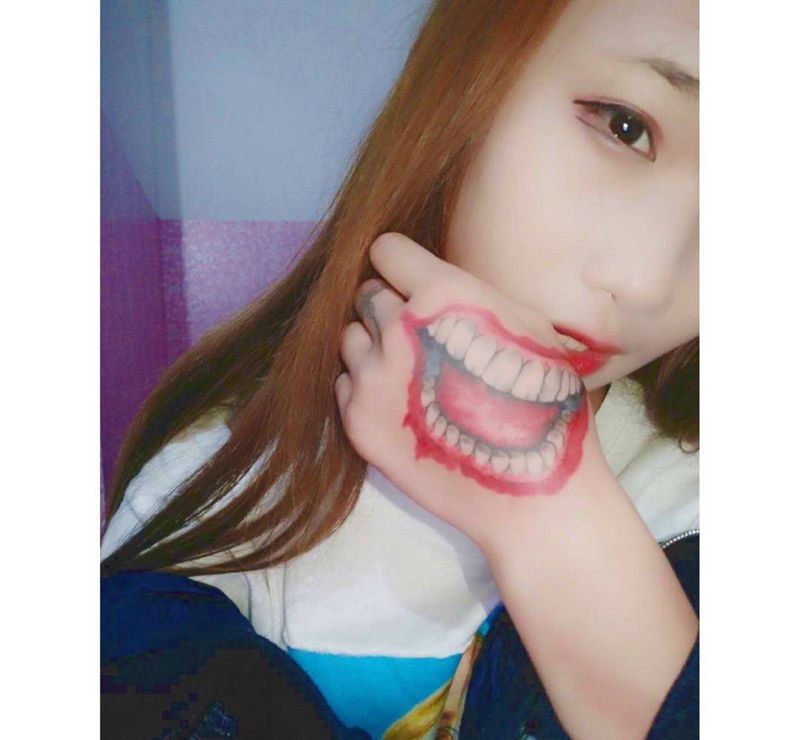 小丑的嘴纹身图片_写实手部成品纹身图案
