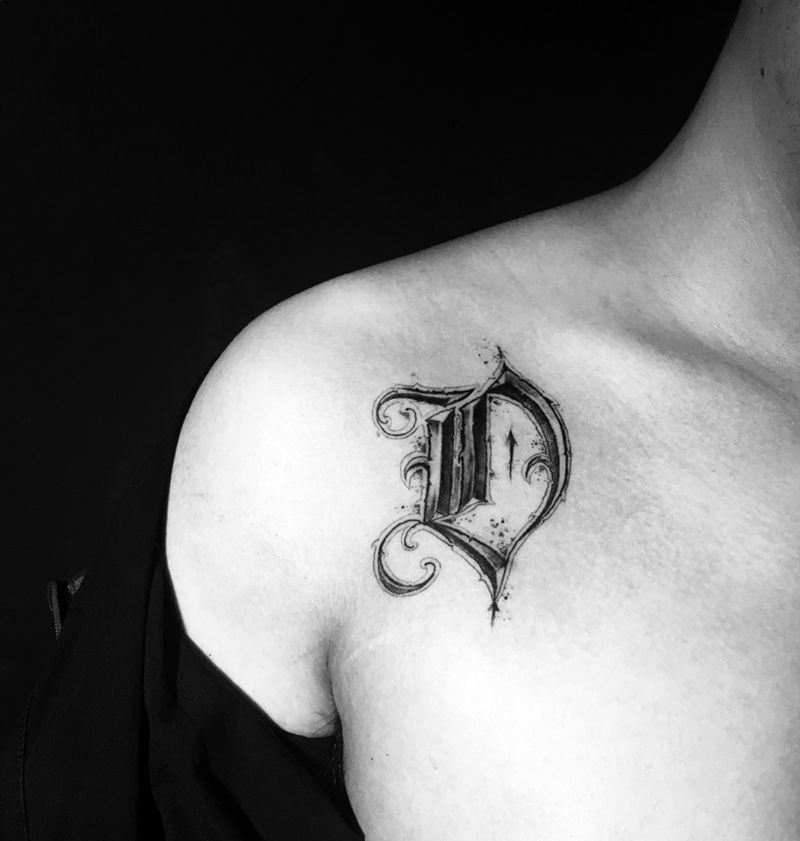 “D”的意志纹身图片_胸部几何花体字纹身图案