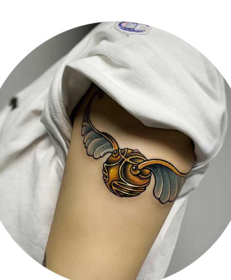 金色飞贼纹身图片_手臂New School哈利波特飞贼卡通纹身图案