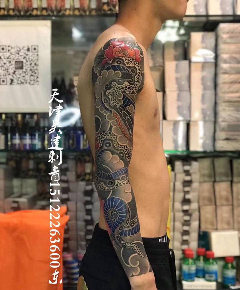 蟒戏牡丹纹身图片_手臂老传统纹身图案
